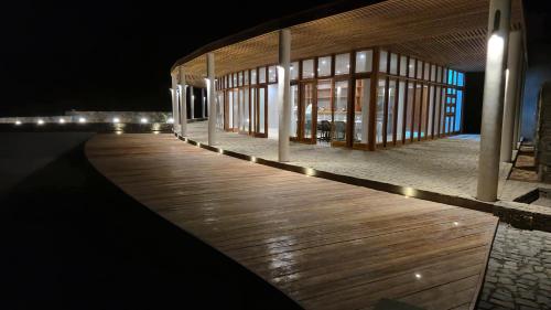 ein beleuchtetes Gebäude an einer Promenade bei Nacht in der Unterkunft Cabo Verde Beach Sport Resort in Porto Novo