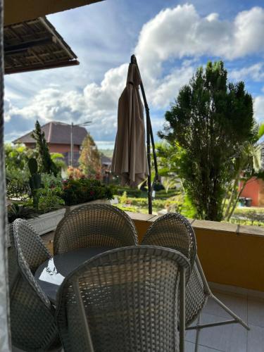 a patio with a table and chairs and an umbrella at Flat Completo 2 Quartos Winterville - Gravatá in Gravatá