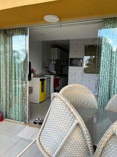 a dining room with a glass table and wicker chairs at Flat Completo 2 Quartos Winterville - Gravatá in Gravatá