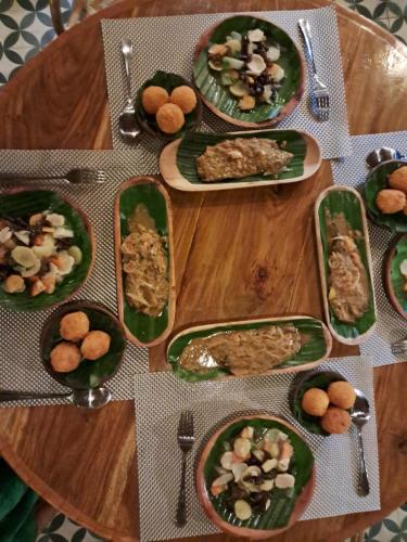 a wooden table with plates of food on it at Villa Maayun, a nest in paradise in Letman