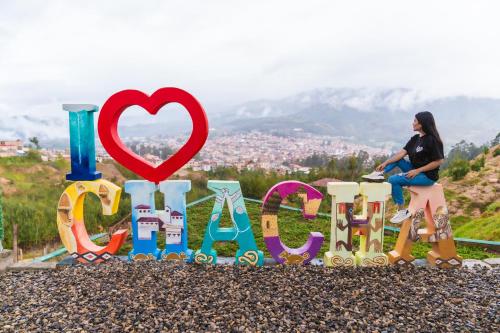 a woman sitting on top of a sign that reads love at Terra Imperial in Chachapoyas