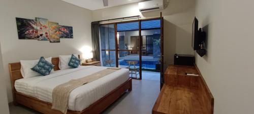 a bedroom with a bed and a television in it at Kubunaku Sanur Bali in Sanur
