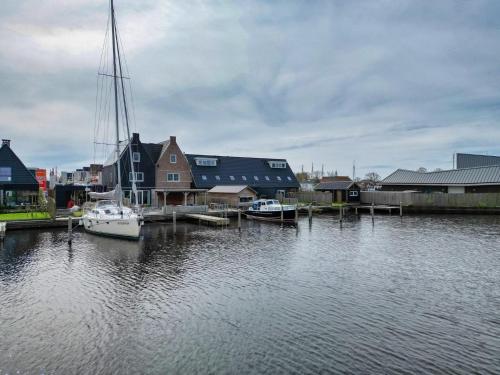 a boat is docked at a dock in a harbor at Waterfront Holiday Home with Terrace & Views in Stavoren