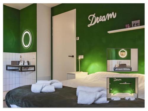 a bedroom with a green wall with towels on a bed at Waterfront Holiday Home with Terrace & Views in Stavoren