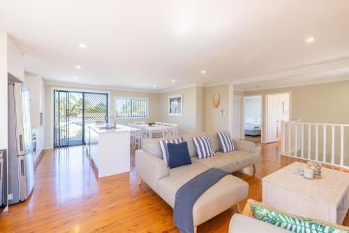 a living room with a couch and a table at Robinson Retreat with Beach Bungalow, 3 Robinson St - air con, 2 kitchens, 6 bedrooms, 4 bathrooms in Anna Bay