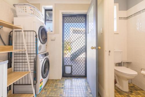 a small bathroom with a washer and dryer at Robinson Retreat with Beach Bungalow, 3 Robinson St - air con, 2 kitchens, 6 bedrooms, 4 bathrooms in Anna Bay