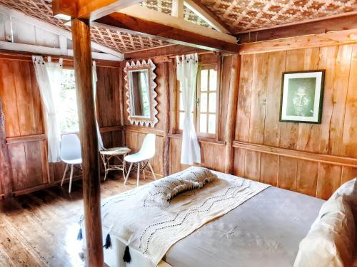a bedroom with a bed and a table and chairs at Villa Maayun, a nest in paradise in Letman