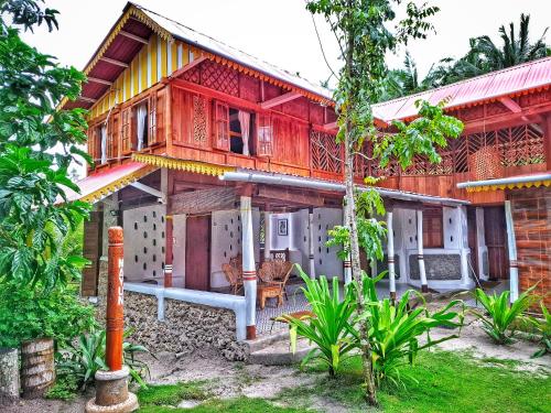 a house with a red and yellow at Villa Maayun, a nest in paradise in Letman