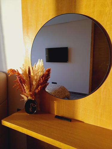 a mirror on a wooden shelf with a vase on a table at Panoramic ocean view appartement in Casablanca