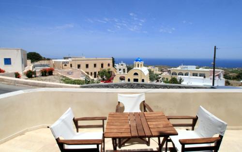 a table and chairs on a balcony with a view of the ocean at Anatoli Hotel & Spa in Fira