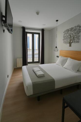 a bedroom with a large bed and a window at CH Lemon Rooms by HEBEROOMS in Madrid
