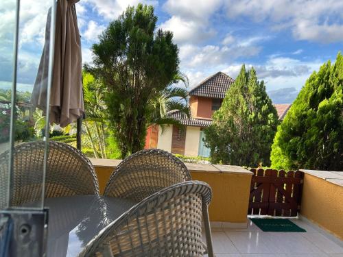 a table with chairs and an umbrella on a balcony at Flat Completo 2 Quartos Winterville - Gravatá in Gravatá