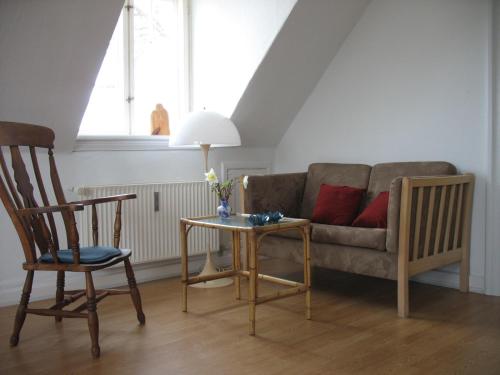 a living room with a couch and a table and chairs at Thurø Kro B&B in Svendborg