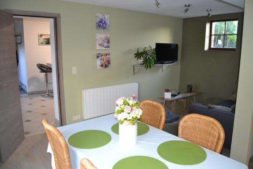 a room with a table with a vase of flowers on it at Gîte de l'Espinette in Godarville