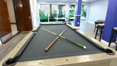 a pool table with two cue sticks on it at 611 Mariners Club in Key Largo