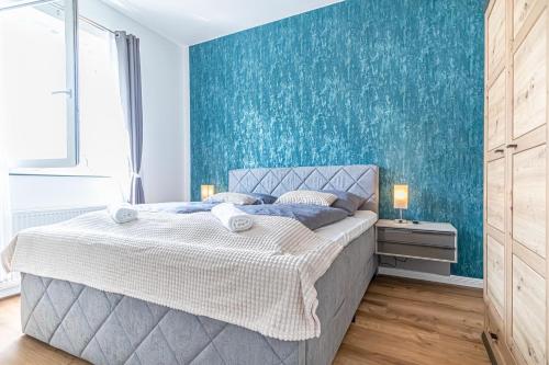 Un dormitorio con una cama con una pared de acento azul en Sweet 2BR & 1LR Apartment, Around Donaustadt, en Viena