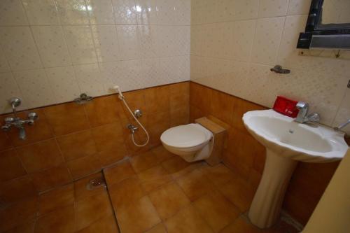 a bathroom with a toilet and a sink at villas holiday family home service in Surat