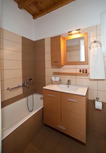 a bathroom with a sink and a bath tub at Sea Wind Villas and Suites in Tourlos