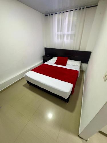 a bedroom with a large bed with a red blanket at Hotel Blue in Santa Rosa de Cabal