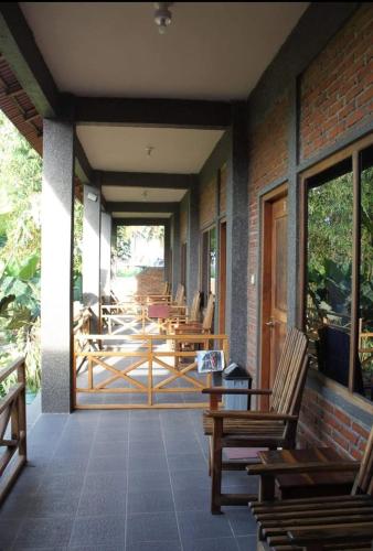 a porch with chairs and tables on a building at Vivian's Lakey peak homestay in Huu