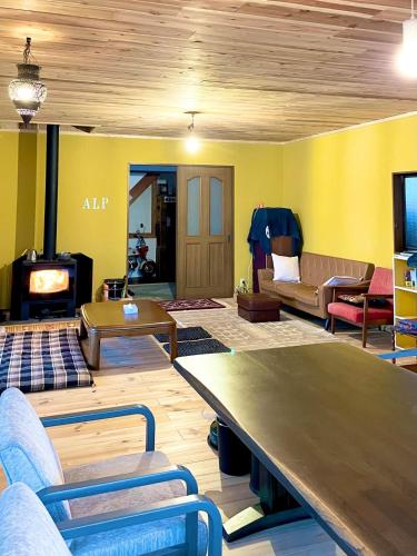 Una sala de estar con una mesa y una chimenea. en 民泊Nao, en Minami Alps