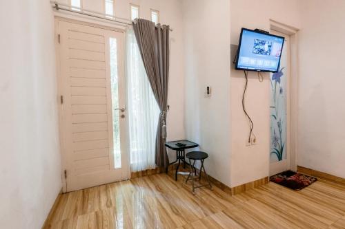 Habitación con puerta y TV en la pared en Umah Putih, en Nusa Penida