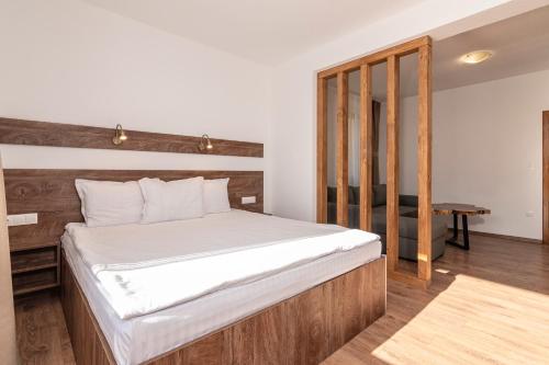 a bedroom with a large bed with a wooden headboard at Spa Villas Daffi in Smolyan