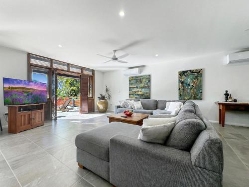 a living room with a couch and a tv at Wongalinga Beachfront Apt 3 in Mission Beach