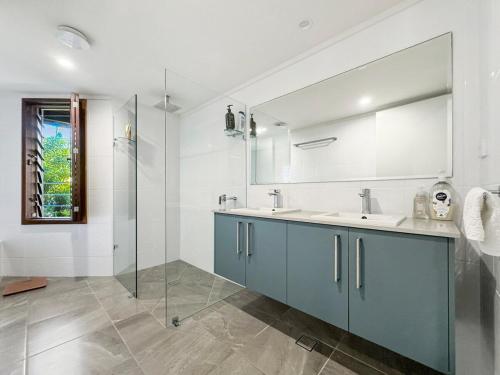 ein Badezimmer mit Waschbecken und Glasdusche in der Unterkunft Wongalinga Beachfront Apt 3 in Mission Beach