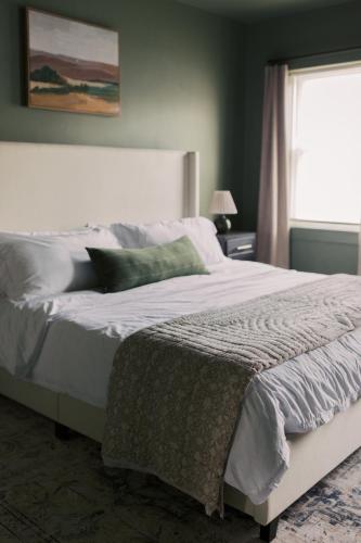 a bedroom with a large white bed with a window at Near Hershey, Entire house with Fire Pit, Game Room in Middletown