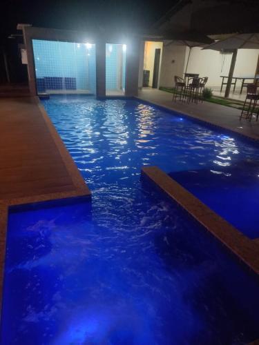 a swimming pool with blue water at night at Sitio trem bao demais in Mateus Leme