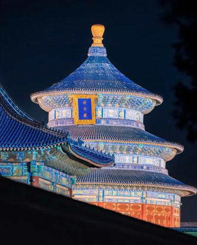 a chinese building lit up at night at Nost algia HotelBeijing Panjiayuan Antique Market 时光漫步酒店北京潘家园劲松地铁站店 Free fresh ground coffee,Free laundry service in Beijing