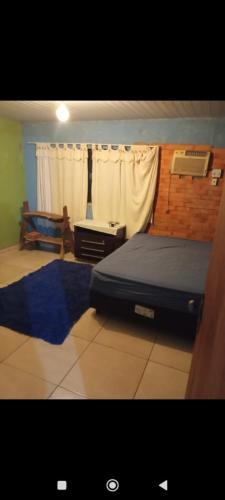 Un dormitorio con una cama y un escritorio y una ventana. en Casa com piscina, en Bonito