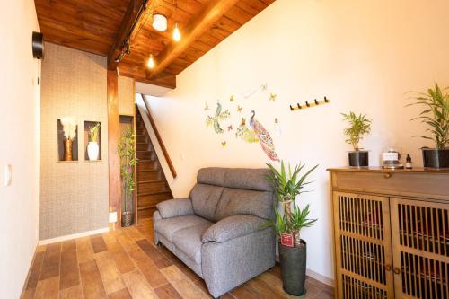 a living room with a couch and some plants at 日本の美術的古民家貸切宿最大8名宿泊可能名古屋駅より8分ジプリや長島リゾートやレゴなどの観光拠点 in Nagoya