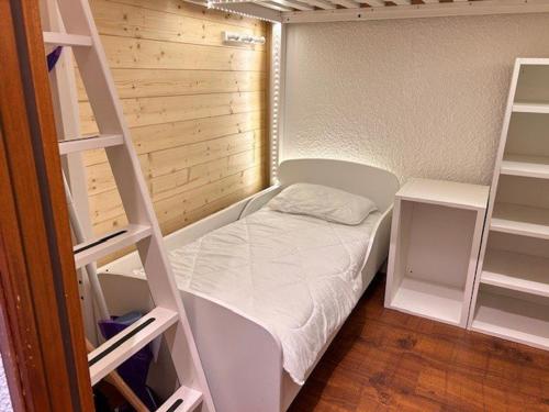 Cette petite chambre comprend un lit et des étagères. dans l'établissement Studio confortable à Risoul, proche pistes et commerces - FR-1-330-548, à Risoul