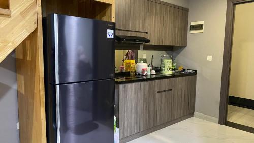 a stainless steel refrigerator in a small kitchen at Apartemen 69m 2 Kamar Tidur dan 2 Kamar Mandi Pemandangan Kota in Medan
