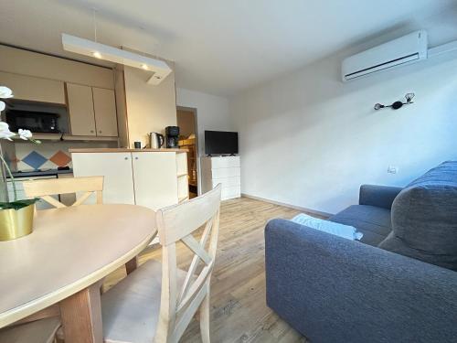 un salon avec une table et un canapé bleu dans l'établissement Cosy- 4 pers Hyper Centre - Plage à 2 min à pied, à Saint-Raphaël