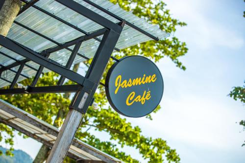 a sign for a sustainable cafe with trees in the background at BJ & Radisson Sea View Hotel in Ko Yao Yai