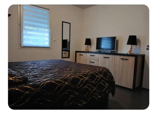 une chambre avec un lit et une télévision à écran plat dans l'établissement maison de vacances au calme avec espace jaccuzi, à La Turballe