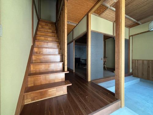 a staircase in a house with wooden floors at P-STAY宮島大西町Hanada in Hatsukaichi