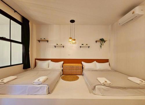 two beds in a small room with two windows at Medina Private Pool Villa-บางแสน in Ban Puk (1)