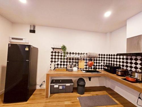a kitchen with a counter and a black refrigerator at Medina Private Pool Villa-บางแสน in Ban Puk (1)