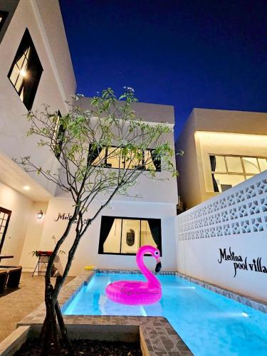 a pink swan in a swimming pool next to a house at Medina Private Pool Villa-บางแสน in Ban Puk (1)
