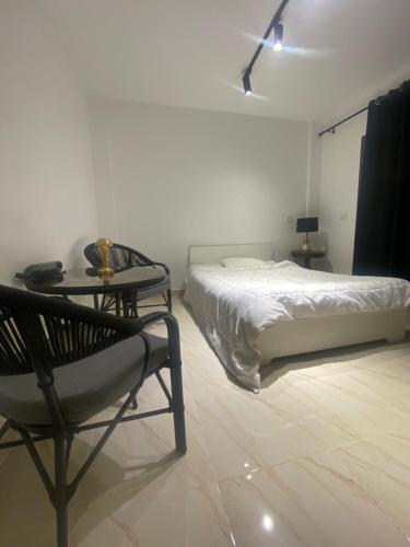 Un dormitorio con una cama, una mesa y una silla. en Vibes Master, en Madinaty