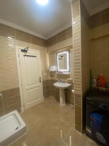 baño con lavabo y puerta blanca en Vibes Master, en Madinaty