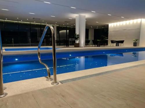 a swimming pool with a hand rail in a building at Departamento Deluxe 2H-48 in Guadalajara