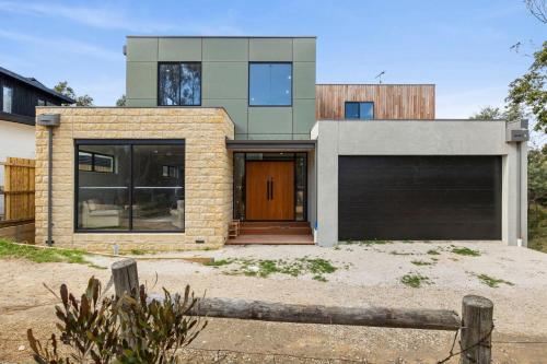 a brick house with a garage in front of it at Gully & Tide in Aireys Inlet