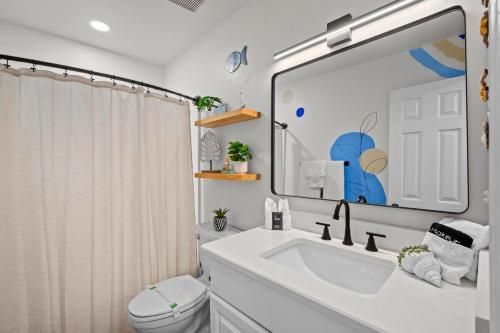 a bathroom with a sink and a toilet and a mirror at Vitamin Sea in Gulf Shores