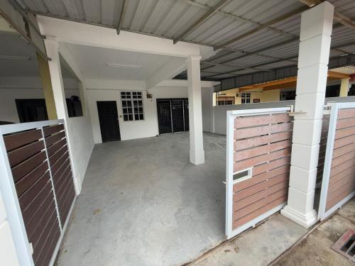 an empty garage with two brown garage doors at Amy's Homestay in Melaka
