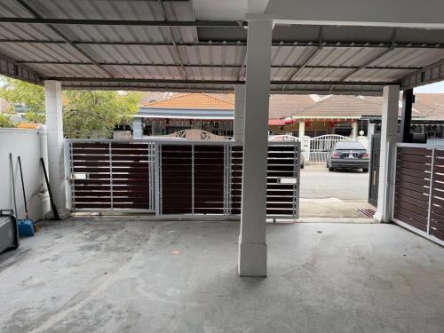 a garage with a metal gate in a parking lot at Amy's Homestay in Melaka